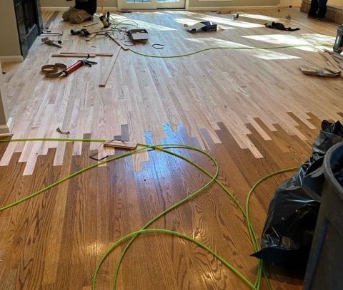 New boards woven into an existing hardwood floor so the repair disappears