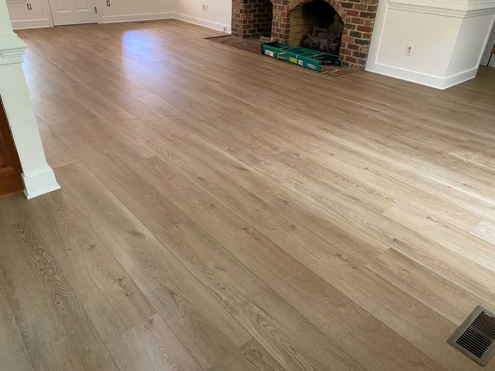Luxury vinyl plank across a living room with a brick fireplace