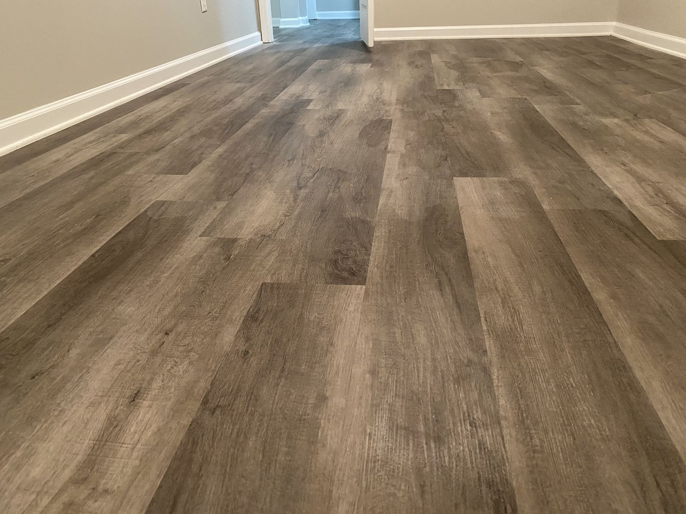 Gray-toned luxury vinyl plank in a room off the hallway