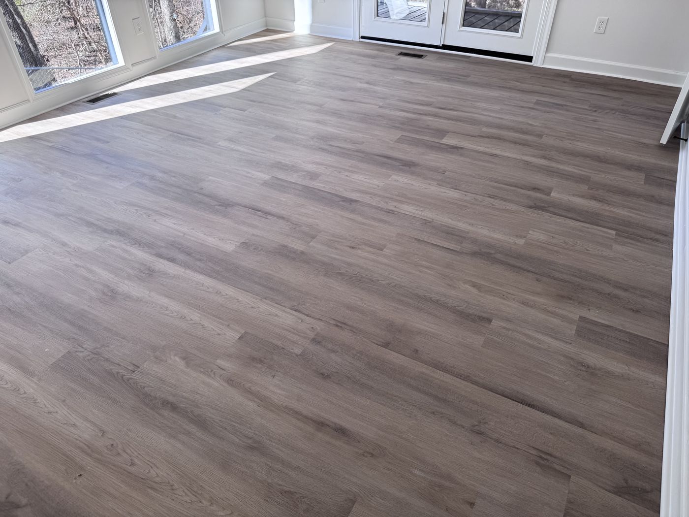 Luxury vinyl plank across a sunroom with French doors