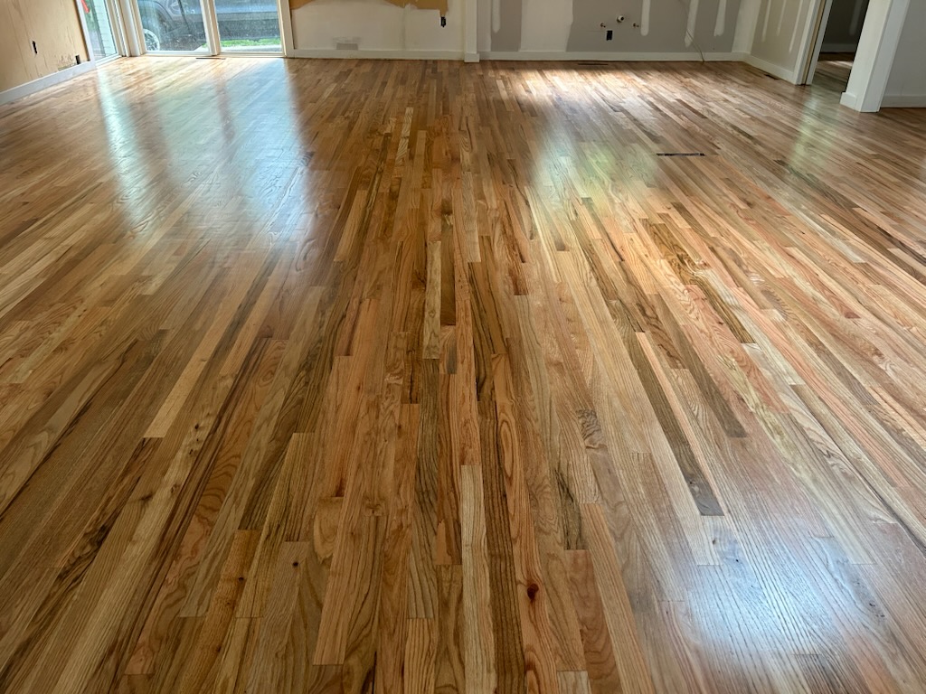 Refinished oak across a large open room, natural finish