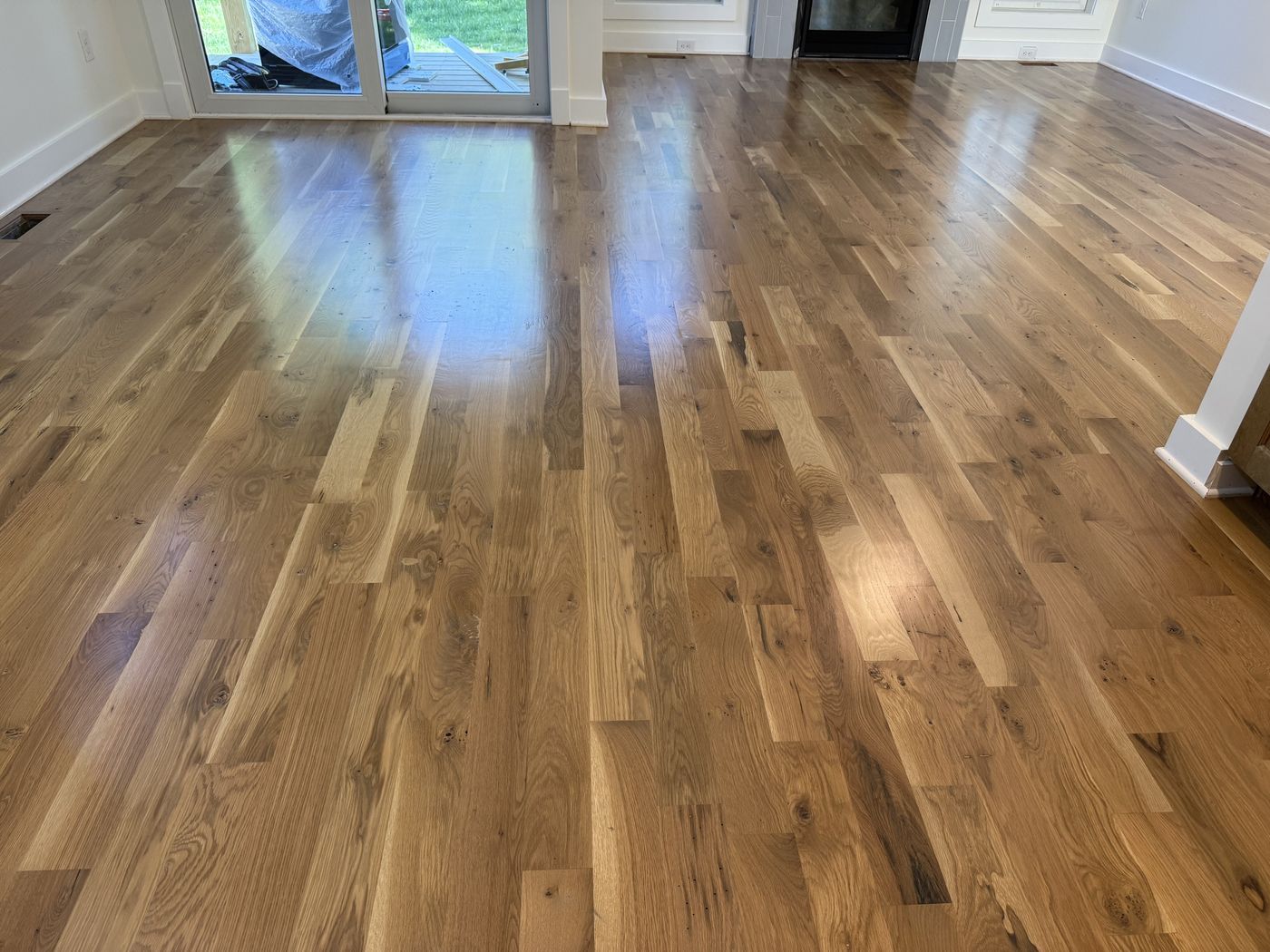 Refinished knotty hardwood in a bright room with a sliding door