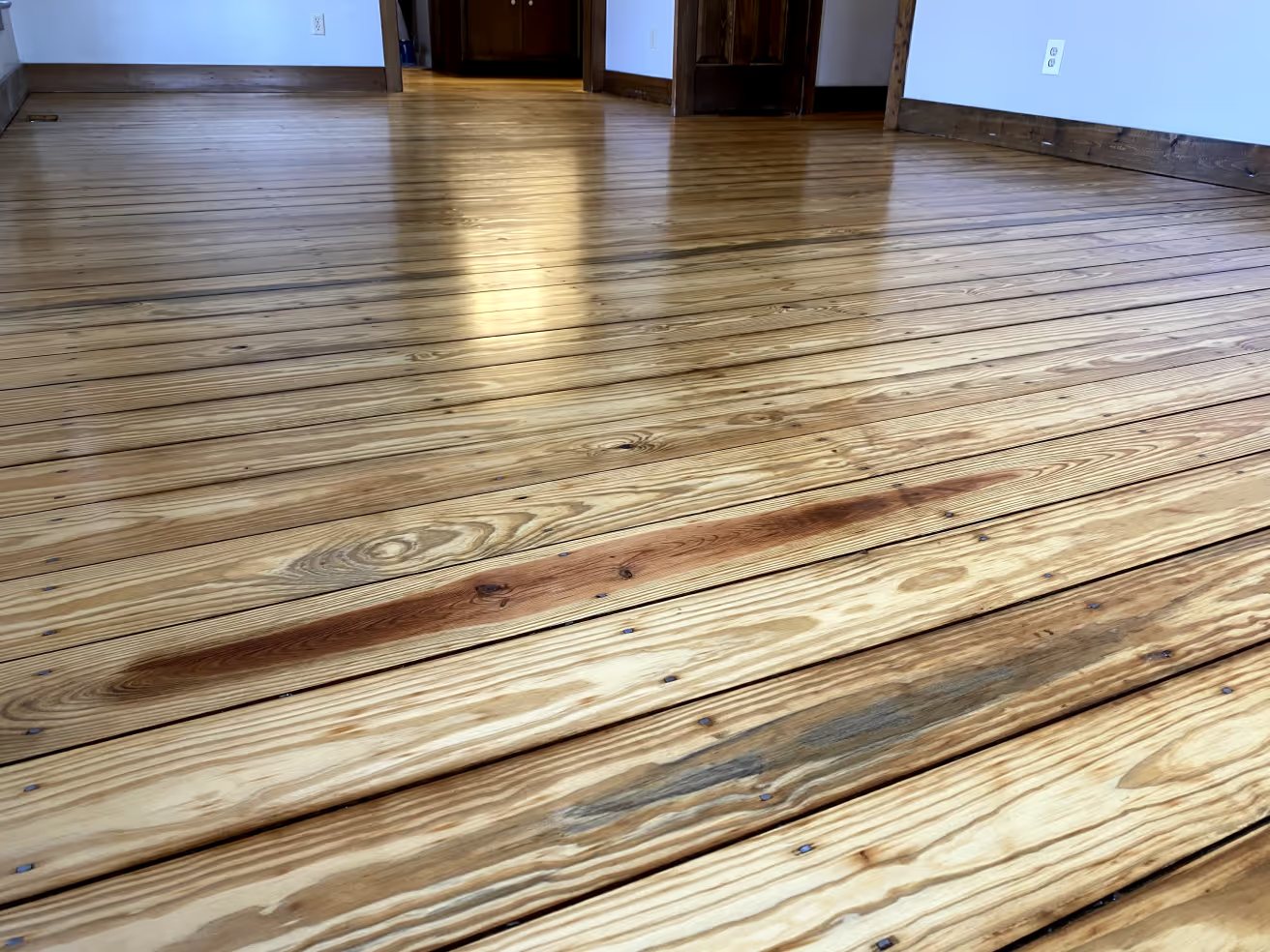 Refinished wide-plank pine, face-nailed, natural heartwood streaks left in