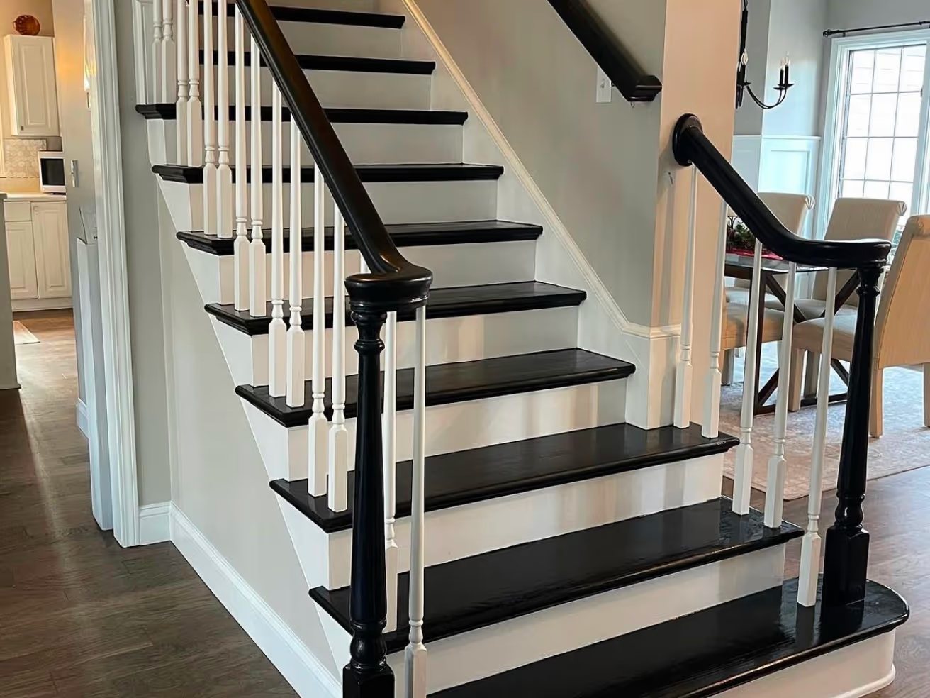 Staircase with black risers and hardwood treads
