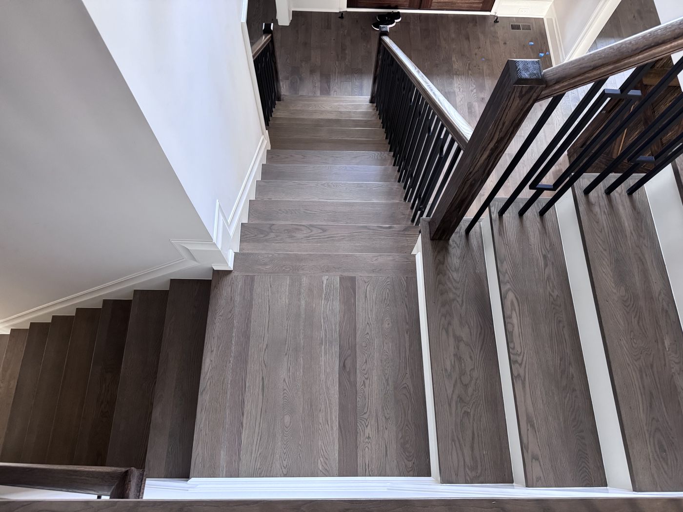 Staircase with gray-stained treads and black balusters