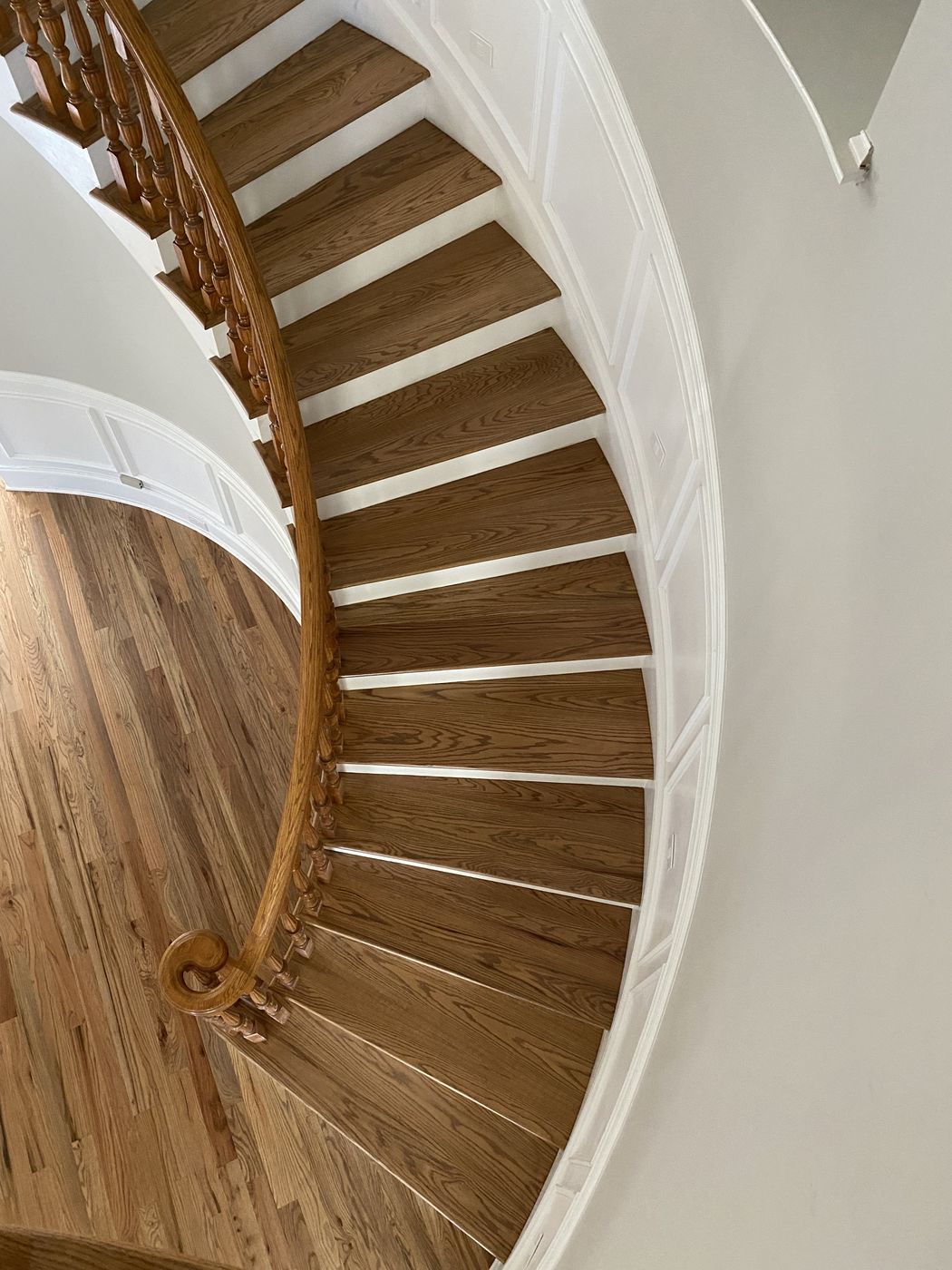 Curved staircase with wood treads and a wood handrail, seen from above