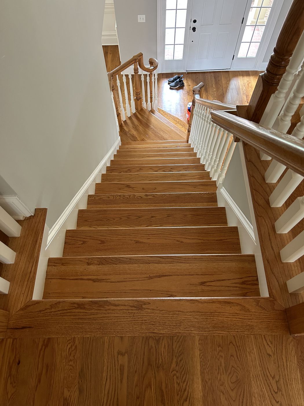 Straight staircase with wood treads and white balusters